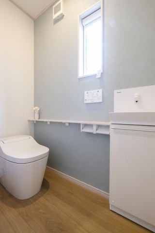 ブルーグレーのアクセントクロスで清潔感のあるトイレ